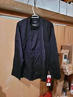 Front view of large black chef's coat by Chefworks, showing double-breasted front with buttons and original tag hanging.