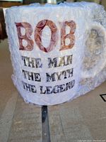 Coffee mug wrapped in bubble wrap with visible 'BOB THE MAN THE MYTH THE LEGEND' text.