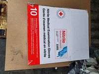 Photo of one unopened box of medium size nitrile medical examination gloves showing the front label and Red Cross branding.