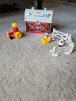 Full view of barn with accessories including farmer on tractor, animals, and fencing on carpeted floor.