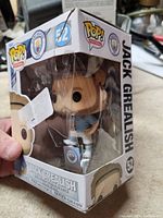 Front and right side view of the Jack Grealish Funko Pop box showing the figure inside and damaged packaging.