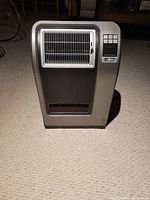 Front view of the Lasco digital ceramic heater showcasing vent grills and digital control panel with display and buttons.