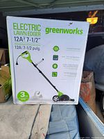 Front view of the boxed Greenworks Electric Lawn Edger with model and specifications.