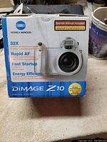 Original Konica Minolta DiMAGE Z10 camera retail box showing product features and Spanish manual included.