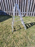 Side angle view of the aluminum step ladder showing foldable A-frame design and multiple steps.