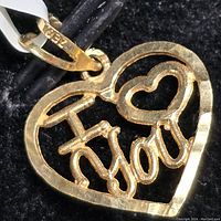 Close-up of the 10kt gold heart-shaped pendant inscribed with 'I Love You'. Shows details of pendant and bail.