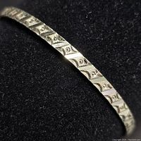 Close-up photo showing detailed textured pattern on the sterling silver bangle.