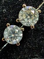 Close-up of single round brilliant diamond in four-prong white gold setting on black background