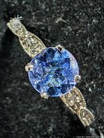 Close-up of round tanzanite center stone and milgrain detailing on shank.