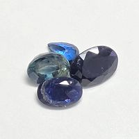 Four loose sapphires exhibiting variety of cuts and blue shades.