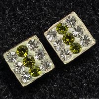 Close-up of the front view of the silver square earrings with green and clear stones