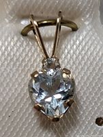 Close-up front view of heart-shaped aquamarine pendant in 10K gold setting.