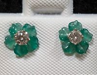 Close-up front view of green agate flower earrings with diamond centers against white textured background.