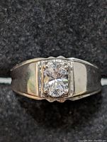 Front view of silver ring showing clear round-cut stone set in square bezel on silver band.