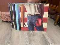 Photo showing a side view of the vinyl records stacked, highlighting the Bruce Springsteen album cover worn condition.