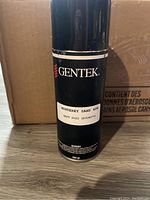 Close-up front view of one Gentek spray paint can with Monterey Sand sticker and expiration date.