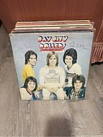 Front view of vinyl records stack showing Bay City Rollers album cover with signatures