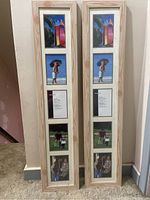 Two tall wooden photo collage frames leaning against a wall, each with five vertical photo slots filled with sample photos.