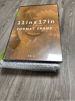 Stack of five new 11x17 inch picture frames packed and wrapped in bubble wrap.