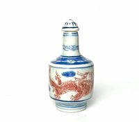 Front view of the porcelain snuff bottle showing the copper red dragon and blue bands decoration.