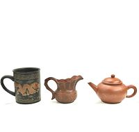 All three items displayed side-by-side: decorative mug, milk pot, teapot.