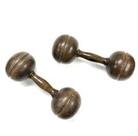 Photo showing pair of vintage wooden dumbbells with round weights and tapered handles on white background.