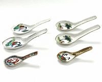 Six antique ceramic spoons arranged in pairs highlighting colorful illustrations of ladies and nature.