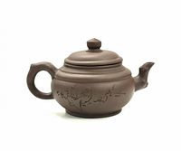 Side view showing the painted bird and floral designs on the teapot body.