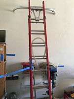 Full frontal view of the 16 ft extendable ladder leaning against a wall showing stabilizer bar attached at the top.