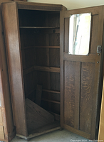 Interior view of cabinet showing multiple shelves, interior mirror on the door, and hooks for hanging items inside.
