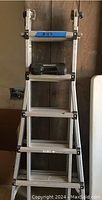 Aluminum Gorilla multi-position ladder with black joints and folded up, showing multiple steps and locking features.