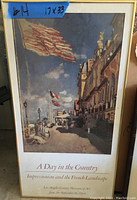 Framed impressionism art poster showing a street scene with flags and buildings, from LACMA 1984 exhibition, measuring 17 x 33 inches.