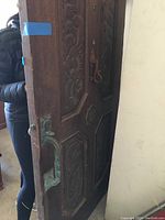 Angle view showing thickness, iron door handle patina, and edge of door.