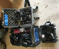 Overview of four foam-lined hard cases containing cameras, lenses and accessories