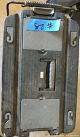 Closed black rolling tool chest with handle and latches, labelled with a blue tape #23.