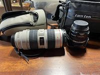 Two lenses (70-200mm and 17-85mm) with beige pouch and Tam Tek bag in background