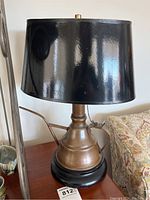 Full view of table lamp showing copper watering can body, black shade, and wood base