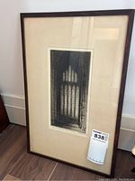 Framed etching of the Five Sisters Window in York Minster leaning against wall on wooden floor.