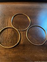Three gold filled bangles showing shape distortions on two thinner bangles.