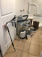 Shows adjustable bed rail, shower chair, scale, humidifier, and some medical equipment arranged in bathroom area