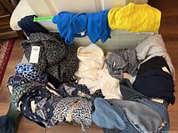 Overview of multiple ladies clothing items including tops, blouses, and sweaters in various colors and prints