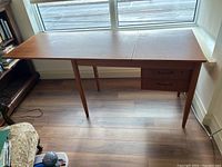 Front view of desk with drop leaf folded down showing full top and drawer section