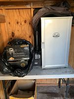 Bradley smoker unit on folding table alongside boxed bisquettes