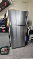 Exterior front view of stainless steel refrigerator with top freezer