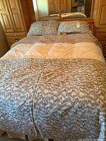 Full view of queen bed made with grey and white patterned duvet cover and pillowcases with solid grey sheets