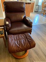Dark brown recliner chair with footstool in front, showing upholstery and structure