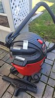 Front side view of Craftsman shop vac showing hose attached and red and black color scheme.