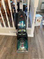 Full front view of Bissell ProHeat Turbo 2X vacuum cleaner showing upright design, cord wrapped on side, and control panel.