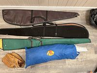Top-down photo showing fishing rod carry cases, blue Bass Pro Shops tent bag, and brown baseball glove.