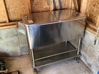 Front view of cooler showing stainless steel body, dual lids and side handle